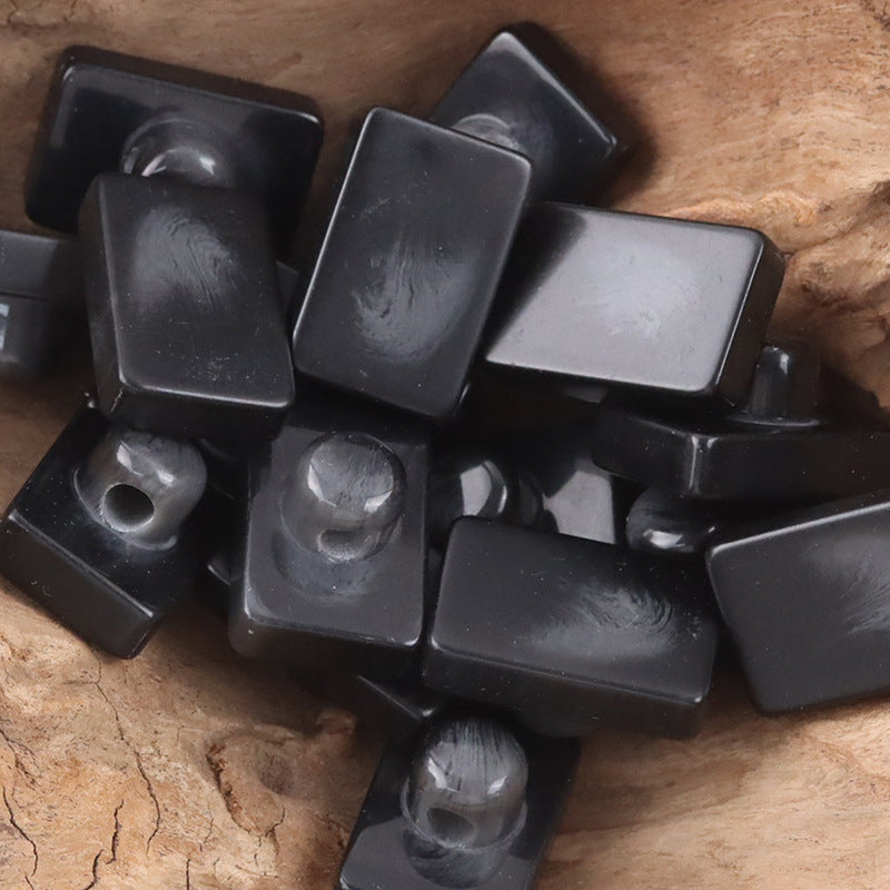 Black rectangular resin buttons with shanks and visible hole detail (assorted)