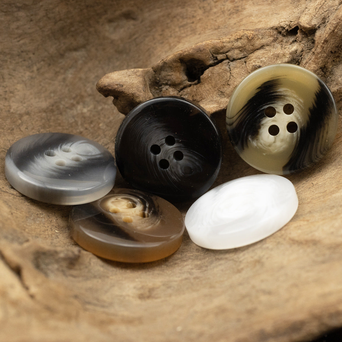 Black resin 4-hole button, round with brush-stroke pattern