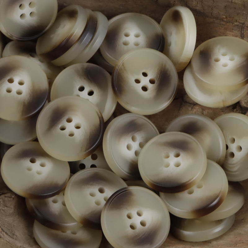 Assorted round resin coat buttons in light khaki tones, multiple 4-hole designs