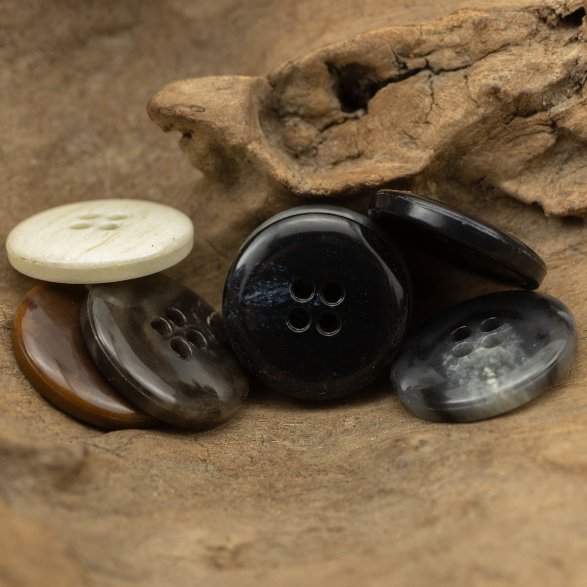 Mixed round 4-hole urea-look buttons with slim edges and fruit-texture finish