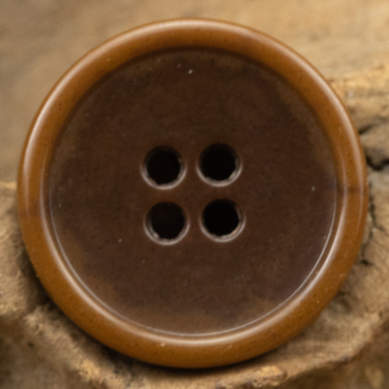 Brown round 4-hole urea-look button with slim edge and imitation fruit texture