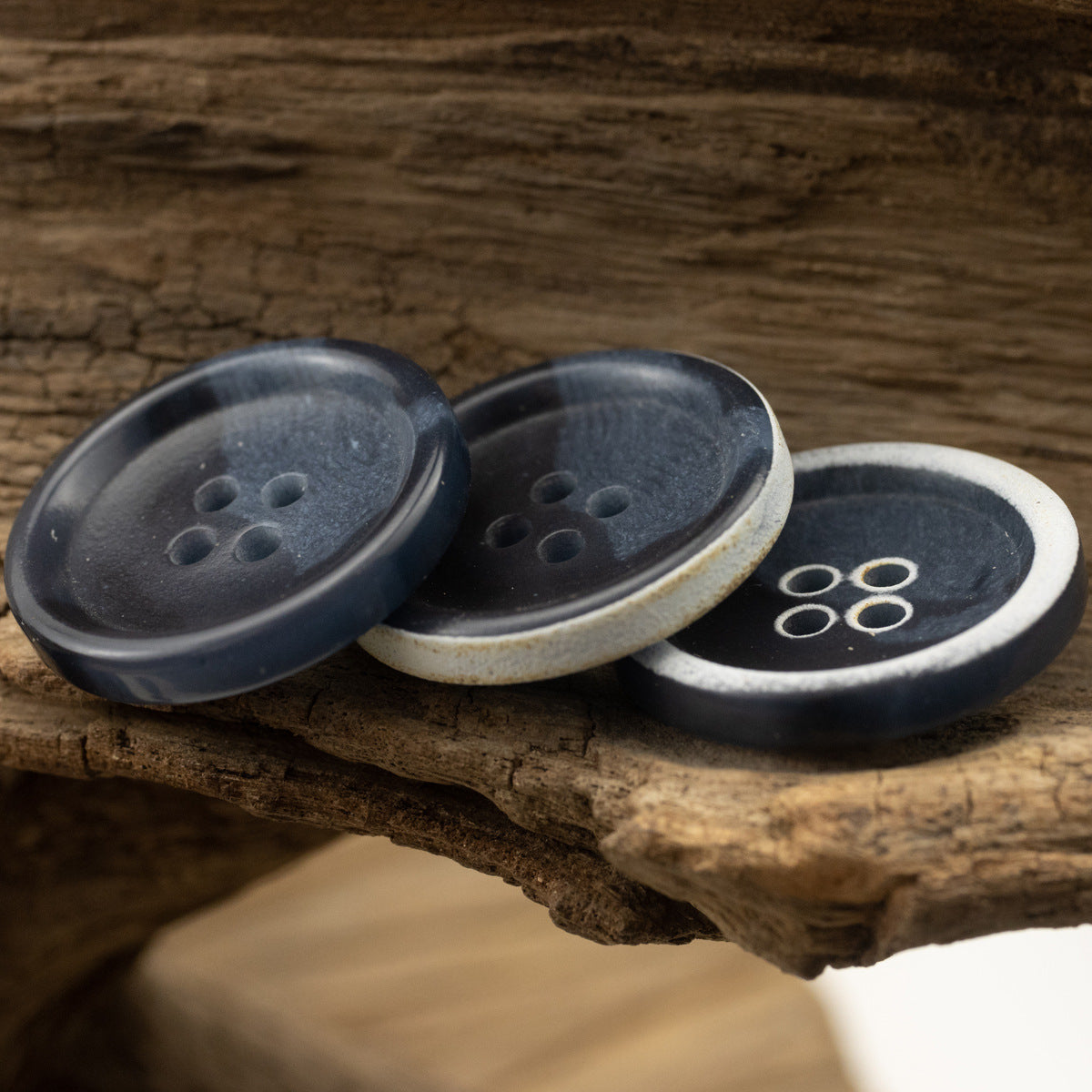 Four-hole dark blue urea buttons, front and back faces on wood