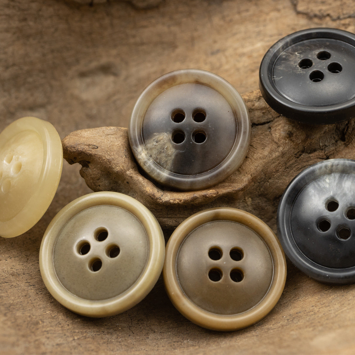 Assorted 4-hole urea coat buttons with glossy dark and light beige finishes