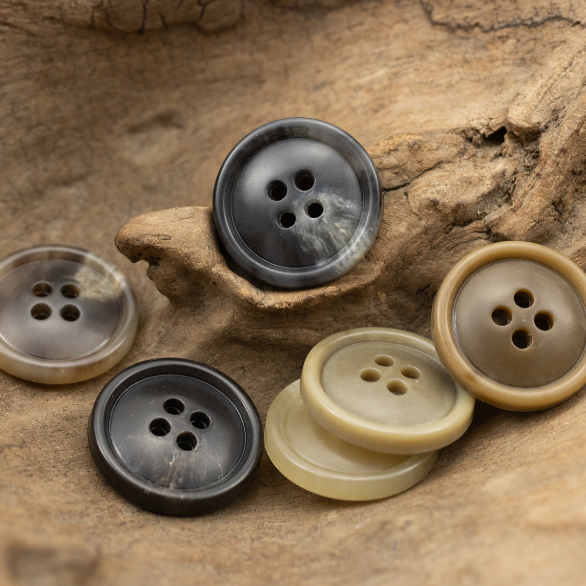 4-hole urea coat buttons in black, gray, beige, and dark brown tones