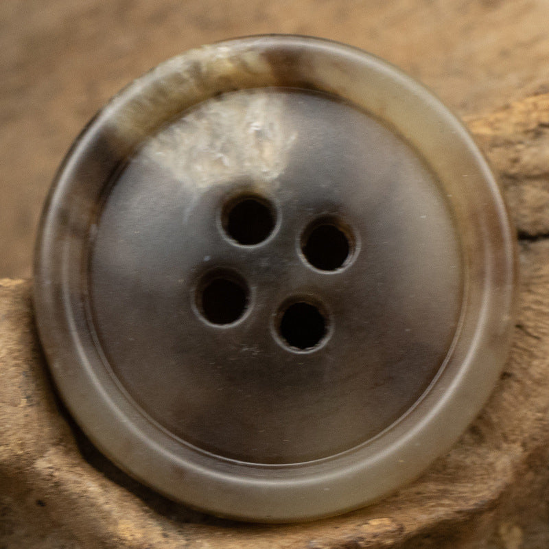 Round 4-hole urea coat button in medium gray-brown with clear sheen
