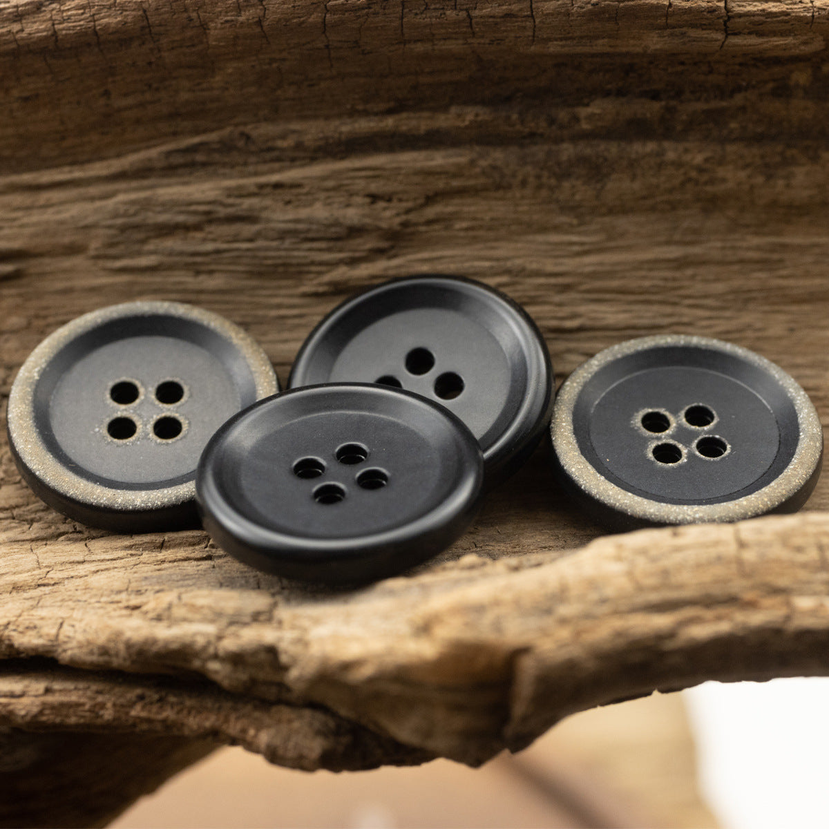 Assorted 4-hole urea buttons in black and burnt-black finishes (small group)