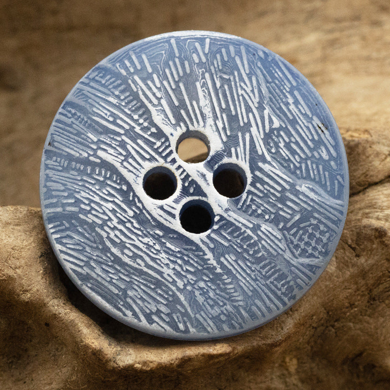 Blue imitation bark button with four holes and distressed bark texture