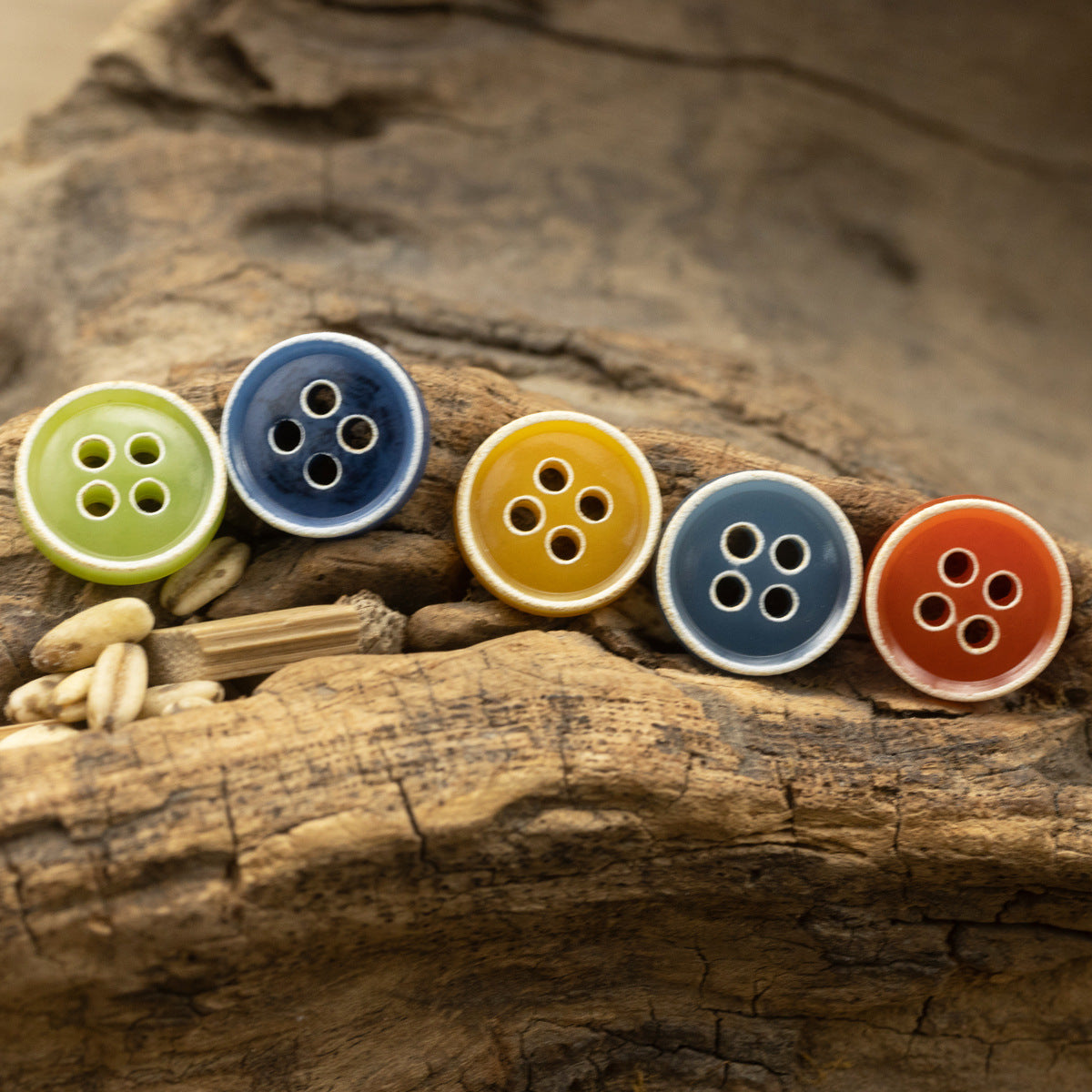 Assorted 4-hole round buttons in lime green, yellow, blue, orange on wood