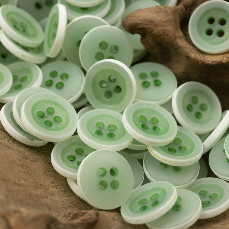 Matte frosted round urea buttons, pale green, four-hole design