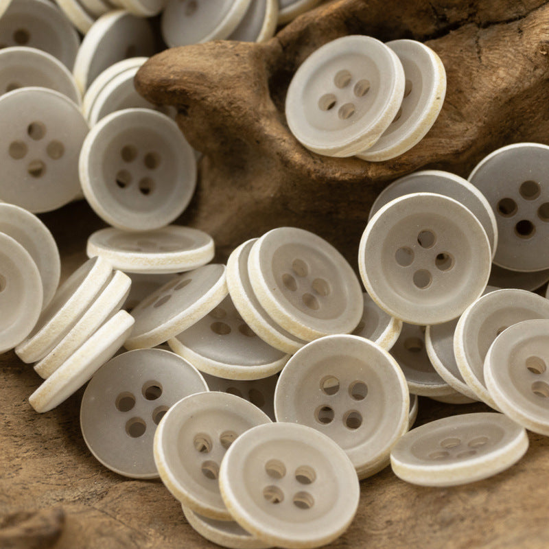 Matte frosted round urea buttons, light gray/white tones, four-hole design