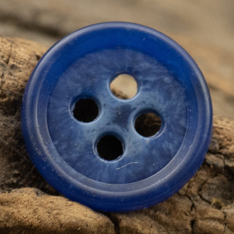 Bright blue round urea shirt button (4-hole) close-up
