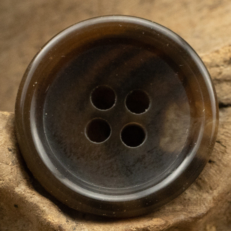 Close-up dark-brown urea coat button with 4 holes and smooth back finish