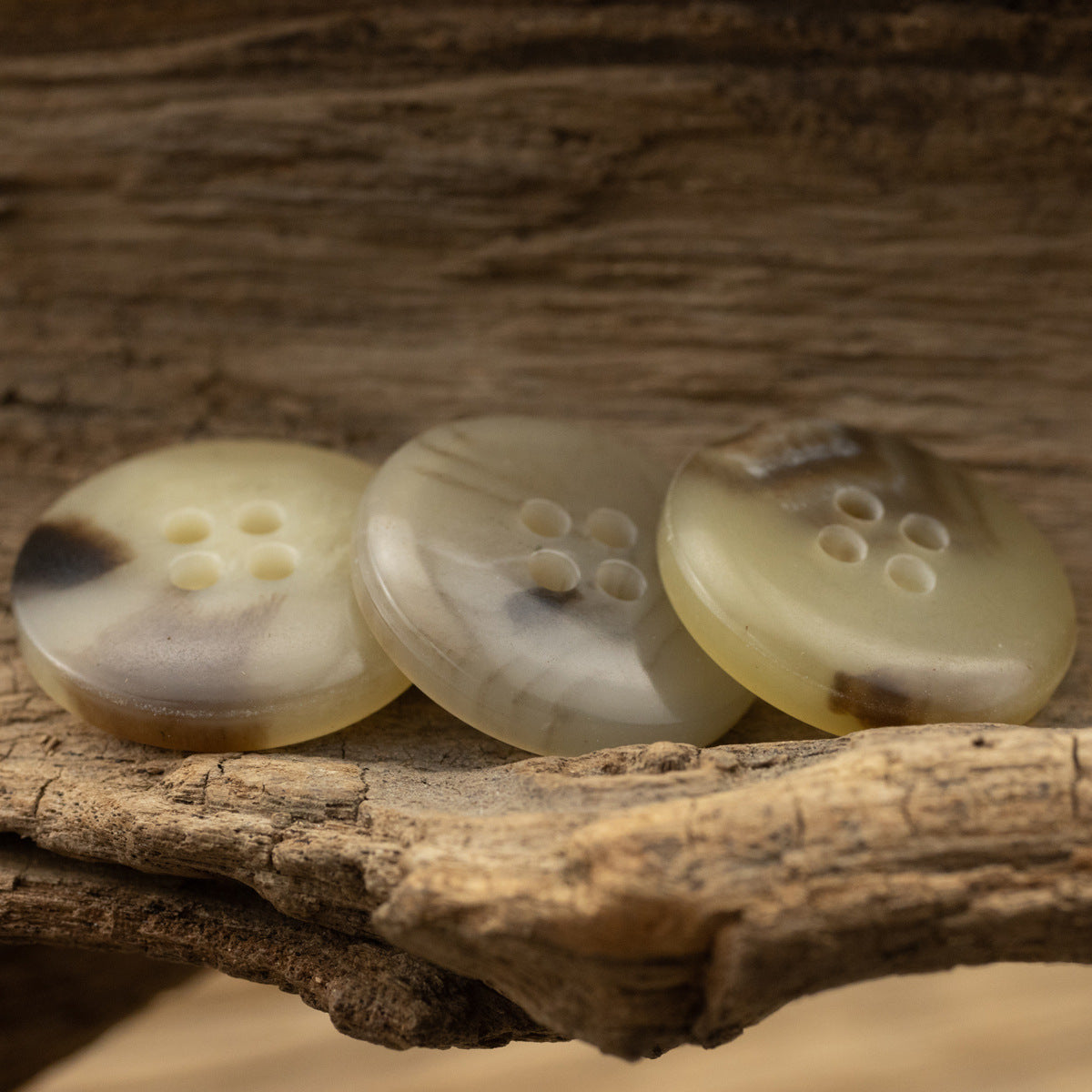 Three khaki round four-hole urea buttons, 15/20mm