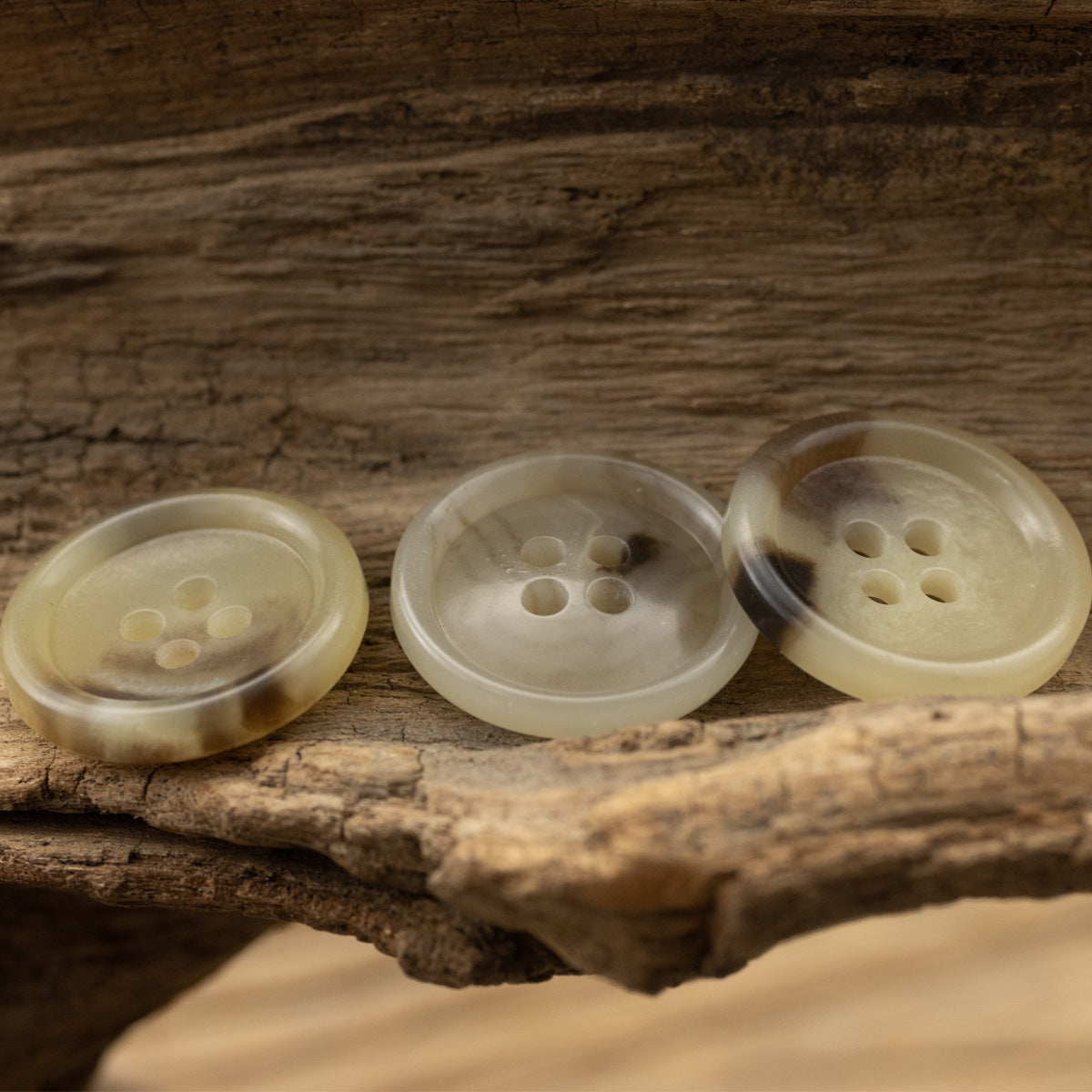 Three khaki round four-hole urea buttons with four-hole layout