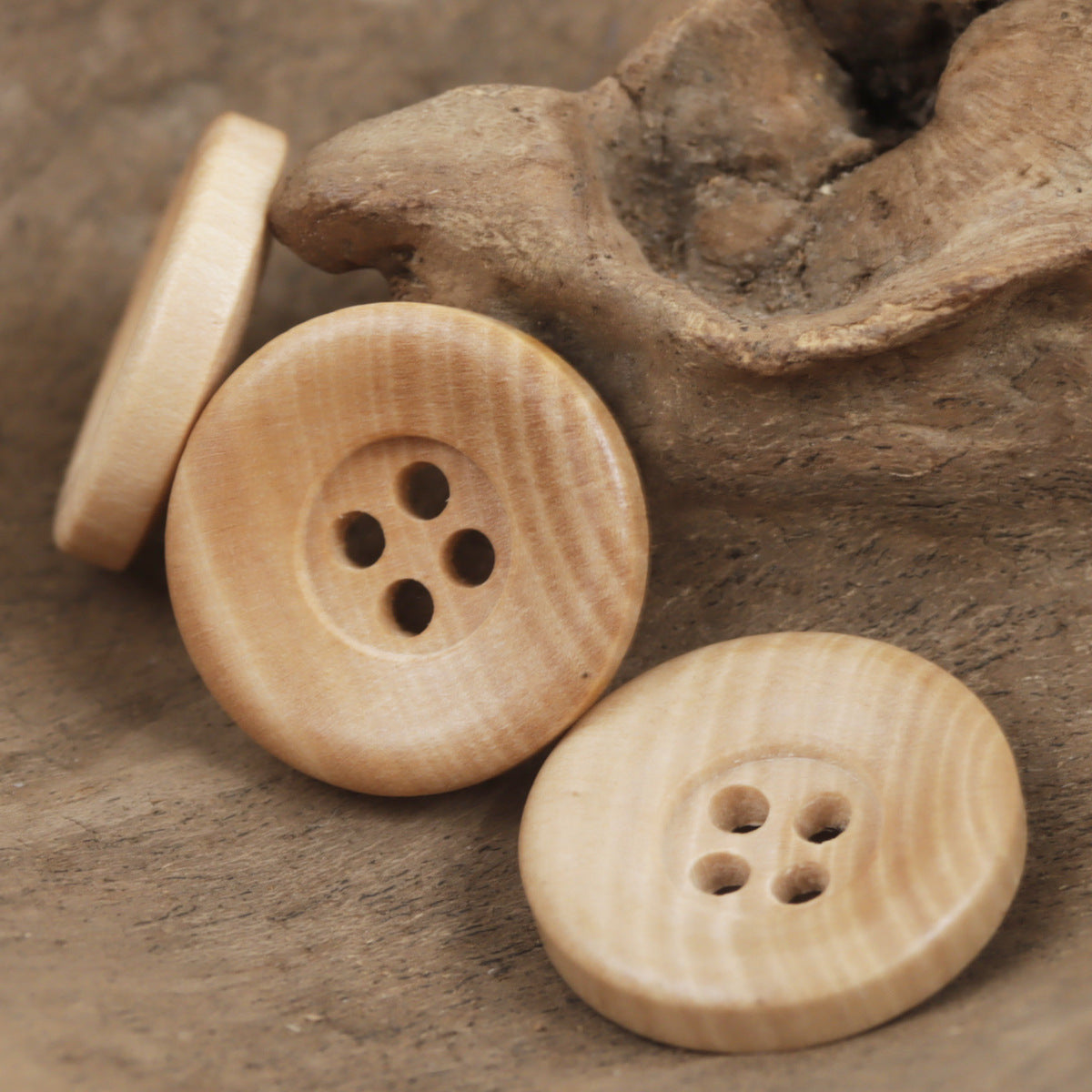 Wooden knitting button pair: one large four-hole button and one smaller four-hole button