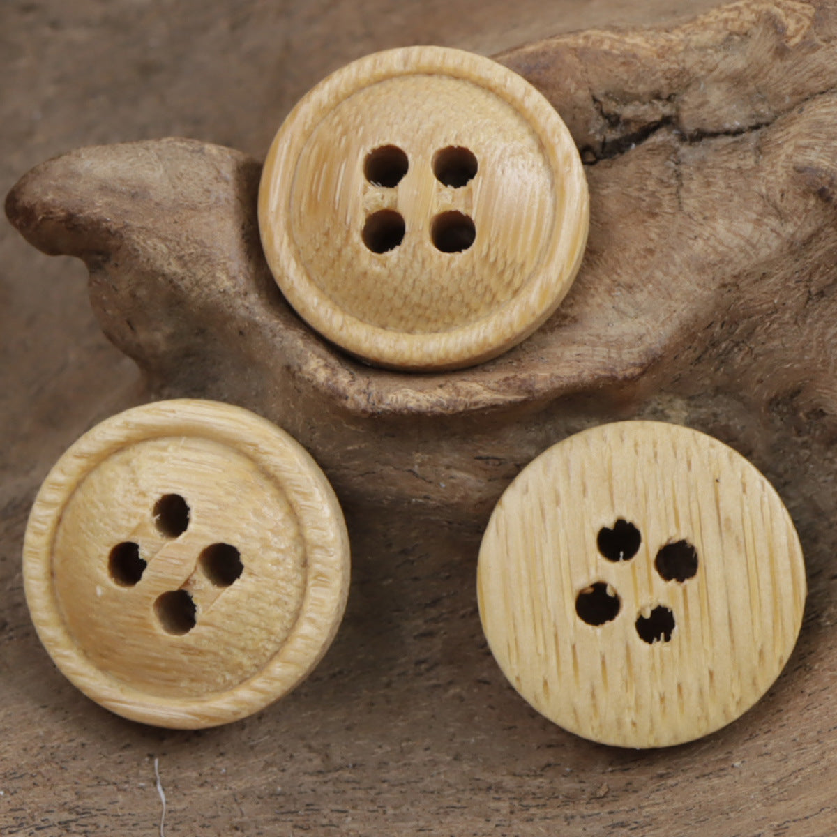Natural bamboo round buttons with four-hole design, light tan color and wood texture.