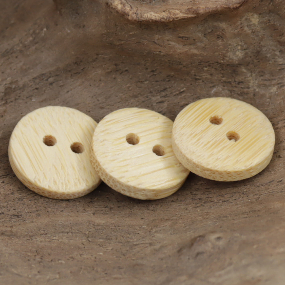 Set of natural bamboo buttons with two holes, light tan, woodgrain texture
