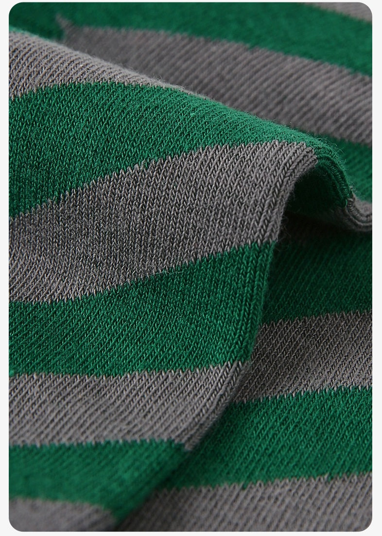 Nahaufnahme: grün-graue gestreifte Socken mit geripptem Bündchen und klaren Farbblöcken
