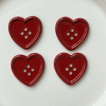 Burgundy heart 4-hole craft buttons, glossy red, four pieces shown