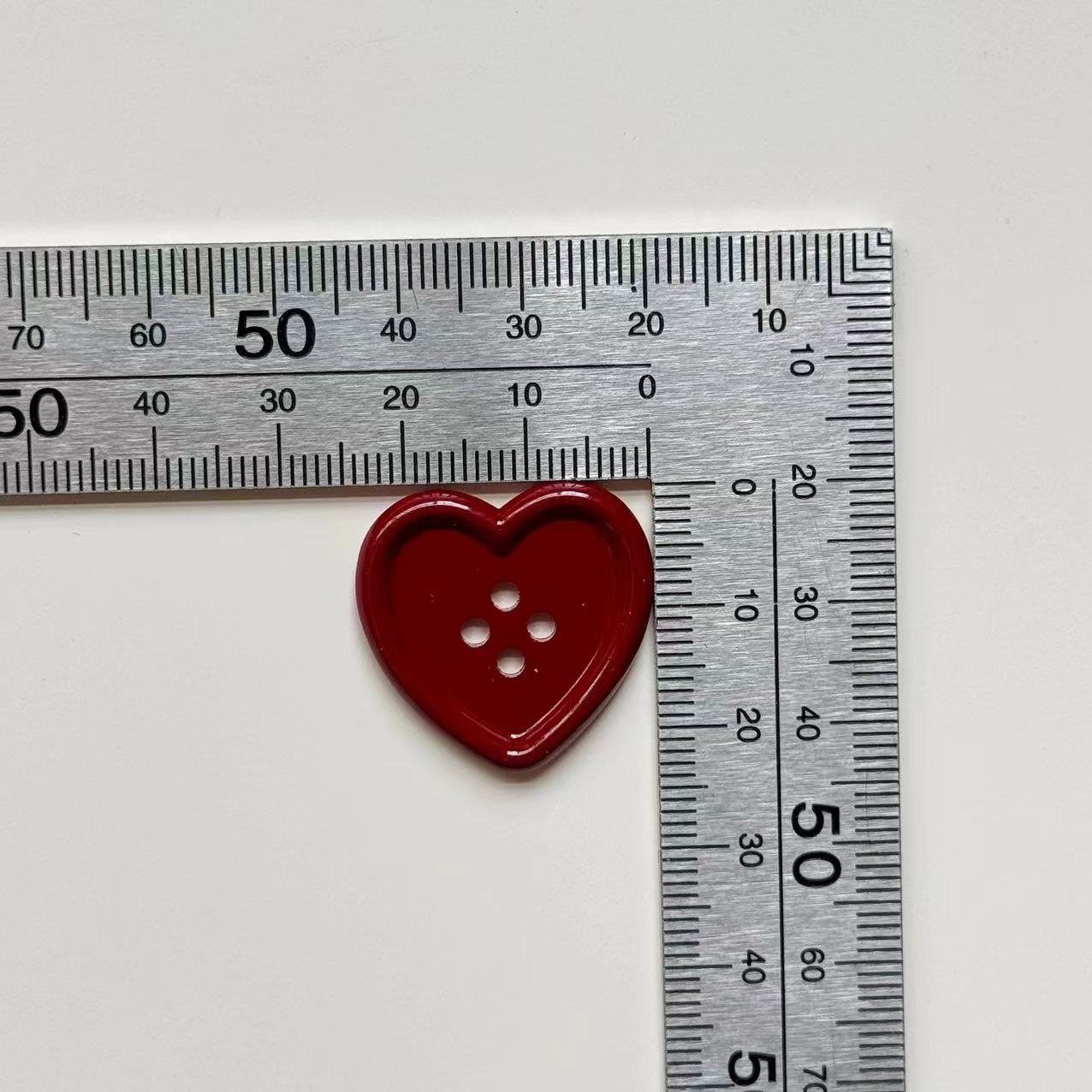25mm burgundy heart 4-hole craft button next to ruler, single piece shown