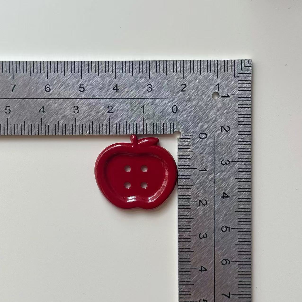 25mm wine red apple 4-hole resin button beside ruler