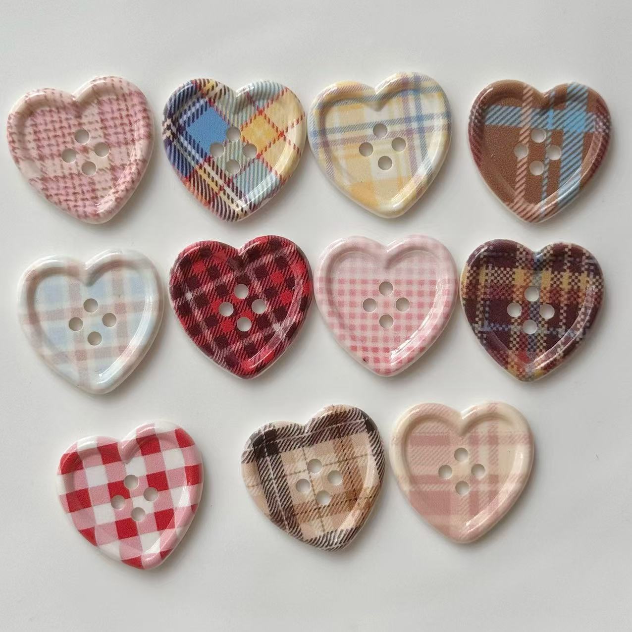 Heart-shaped plaid craft buttons with four holes, mix of pink, red, brown and cream