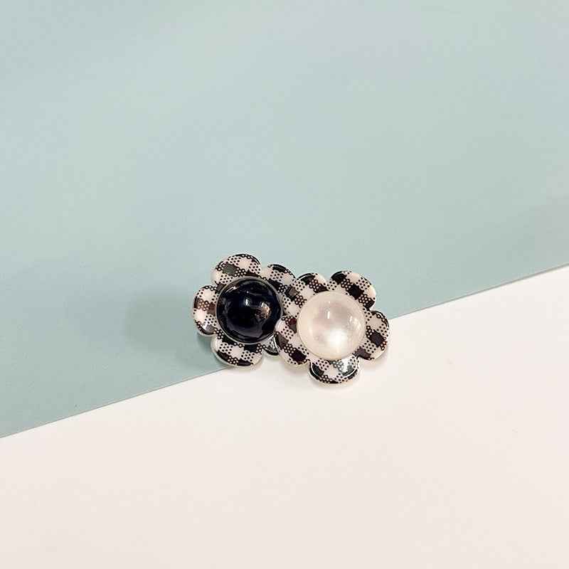 Black-and-white check flower shank button with dark and white pearl centers.