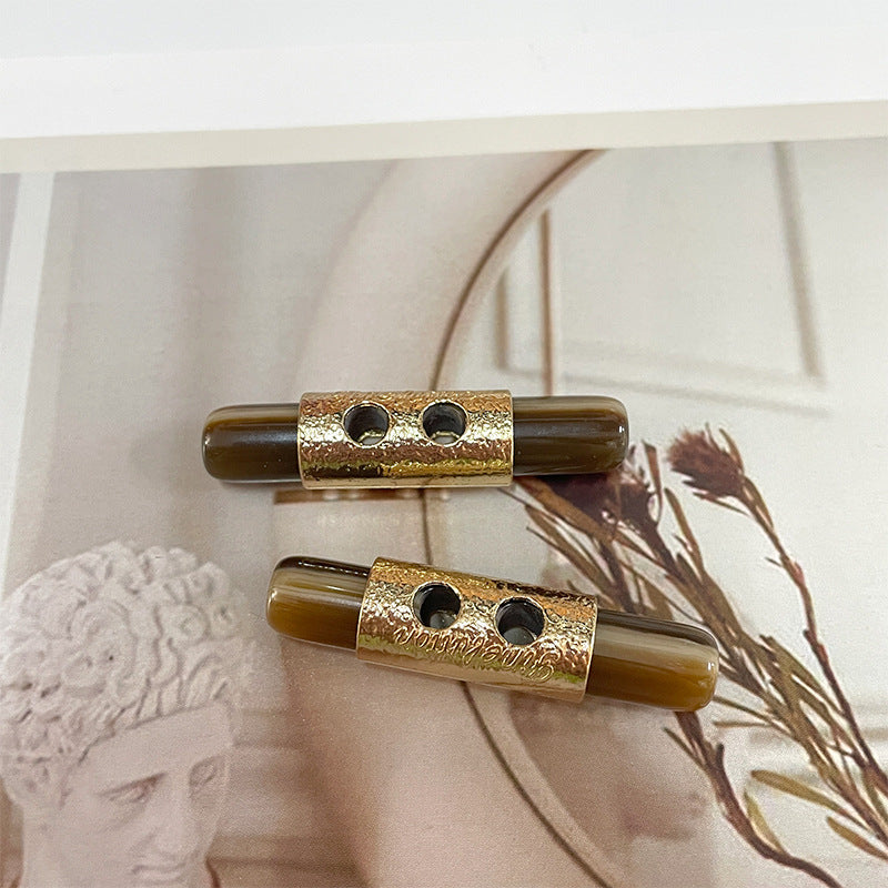 Pair of 50mm resin toggle buttons: dark brown with gold center bar and 2 holes