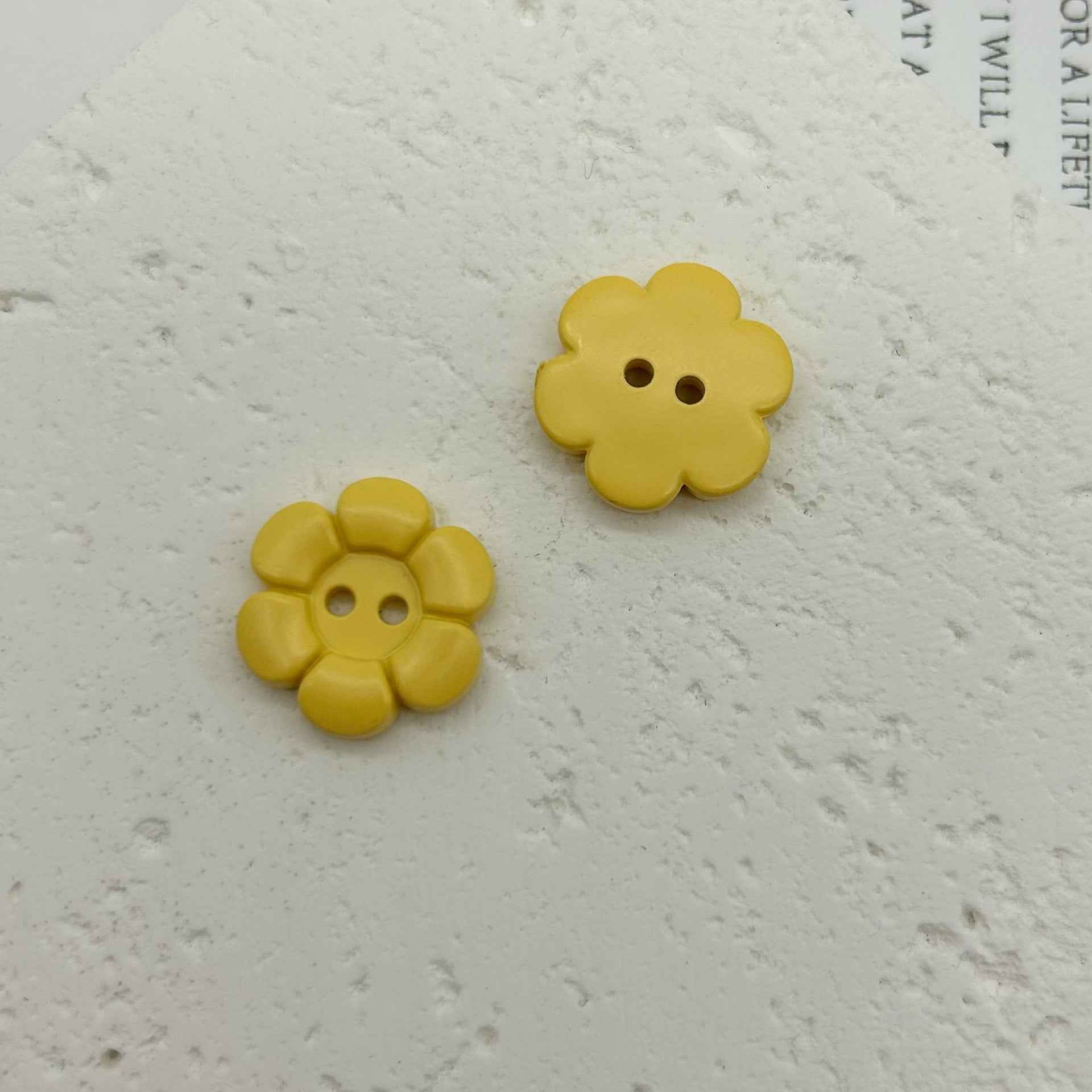 Gelbe blumenförmige Kunststoffknöpfe mit zwei Löchern, 2 Stück