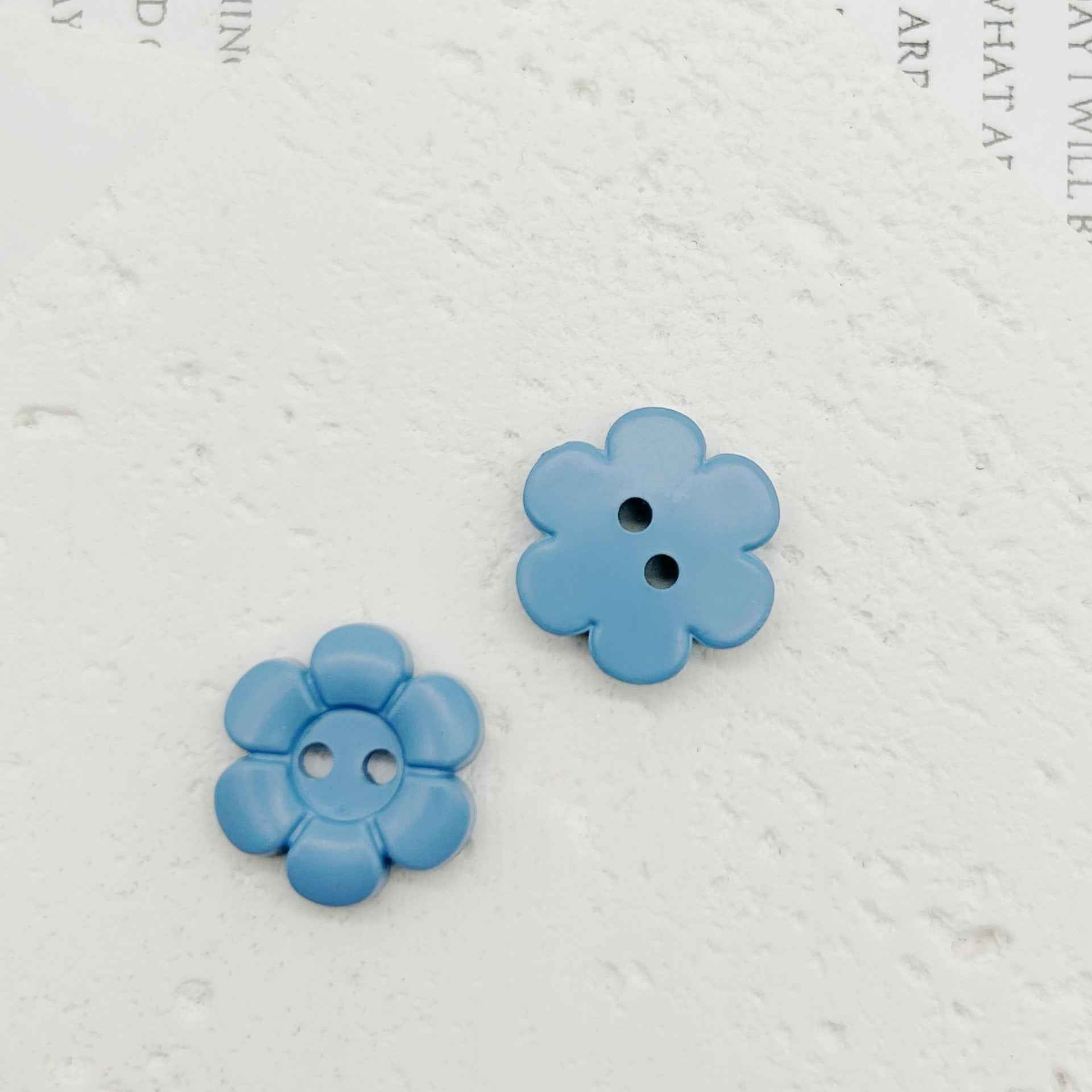 Hellblaue blumenförmige Kunststoffknöpfe mit zwei Löchern, 2 Stück