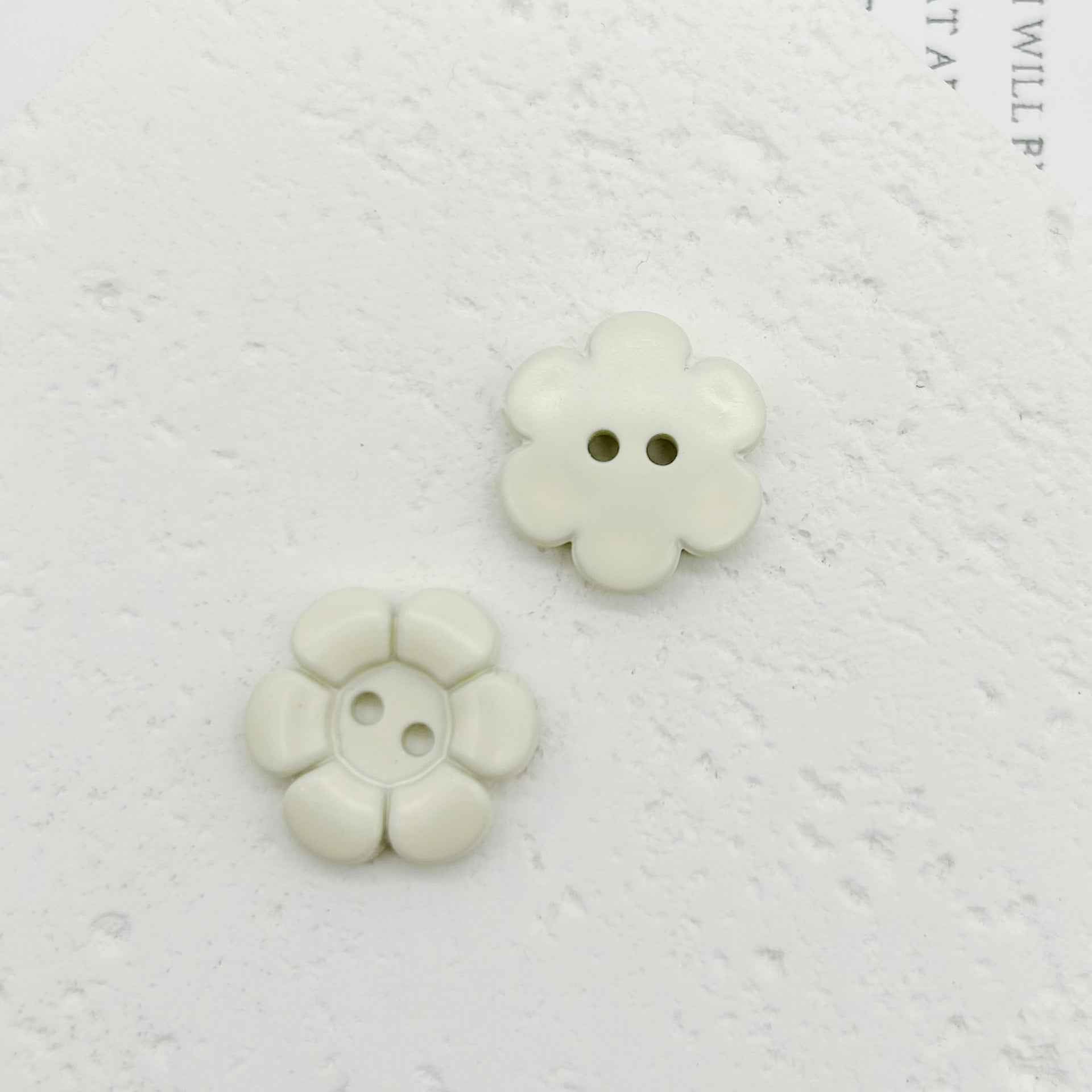 Weiße blumenförmige Kunststoffknöpfe mit zwei Löchern, 2 Stück