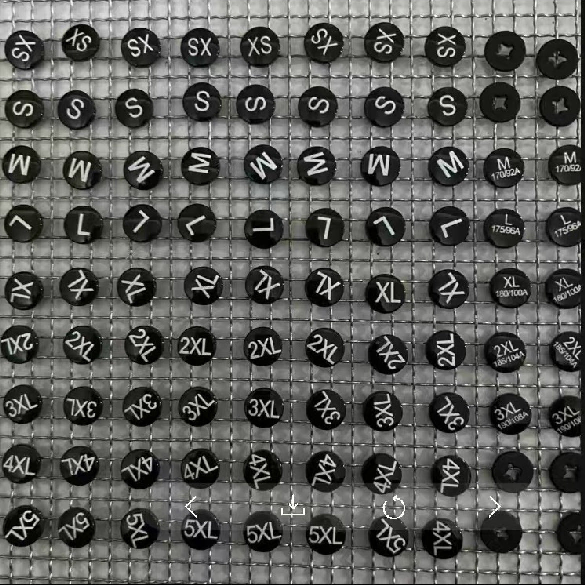 Schwarze runde 2in1 Snap-Buttons mit Größenaufdruck auf Gitter, mehrere Größen