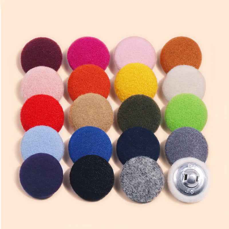 Round fluffy fabric buttons with metal shank, assorted colors on a light background
