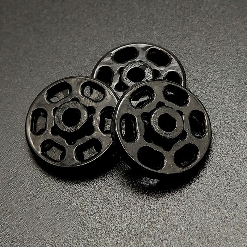 Black round nylon snap buttons, close view of front discs and holes