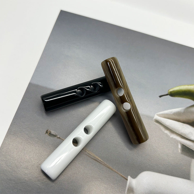 Set of long cylindrical resin toggle buttons: black, white and olive green