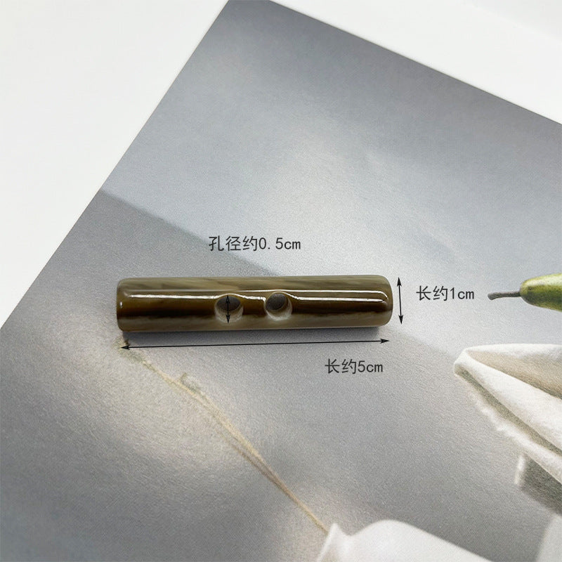Olive green long resin toggle button, two holes; ~5cm x ~1cm