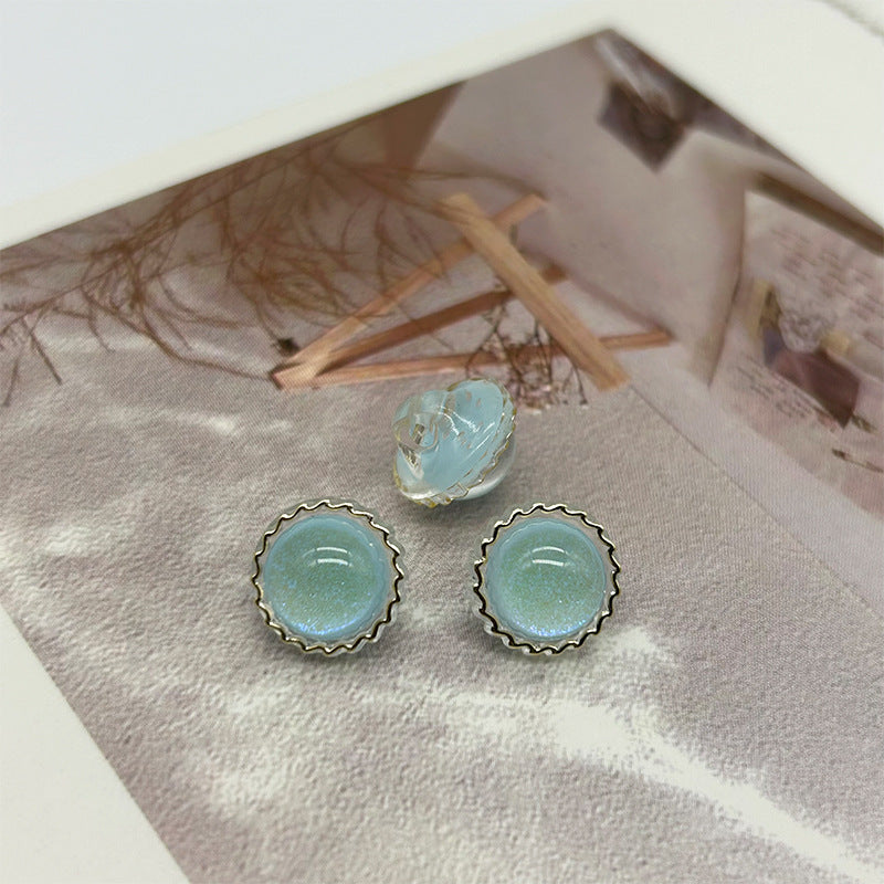 Light blue glitter round buttons with scalloped metal rim and two shank grooves