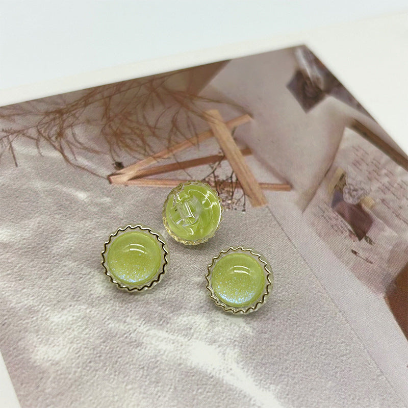 Green glitter round buttons with scalloped metal rim and two shank grooves