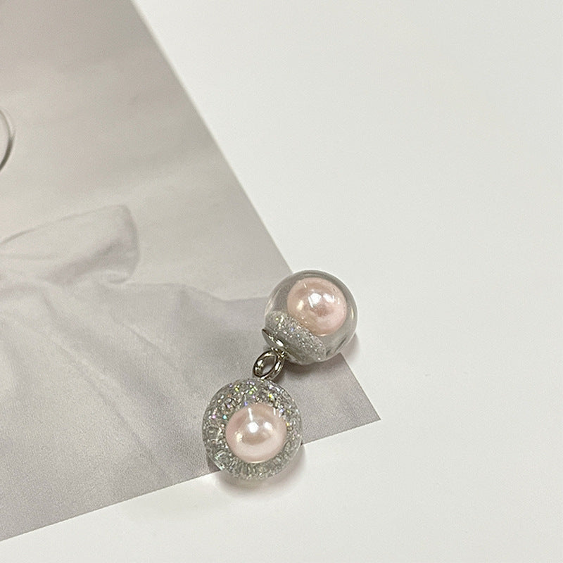 Peach-pink round pearl-style button with clear top and silver metal loop