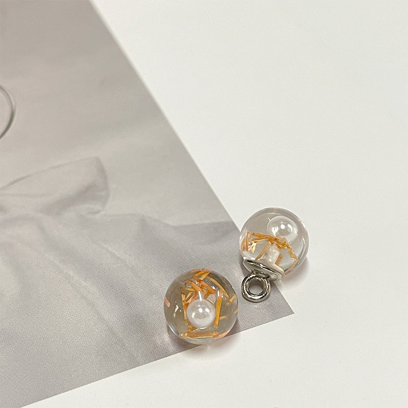 Amber-gold foil round pearl-style button with white pearl center and silver loop