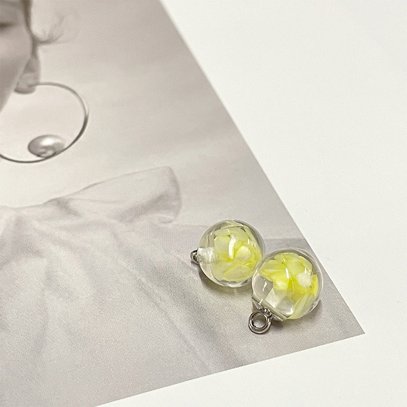 Lime yellow round pearl-style button with clear top and silver metal loop