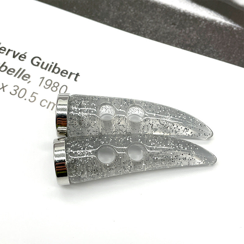 Close-up: silver glitter horn toggle button with two large openings and shiny metal rim