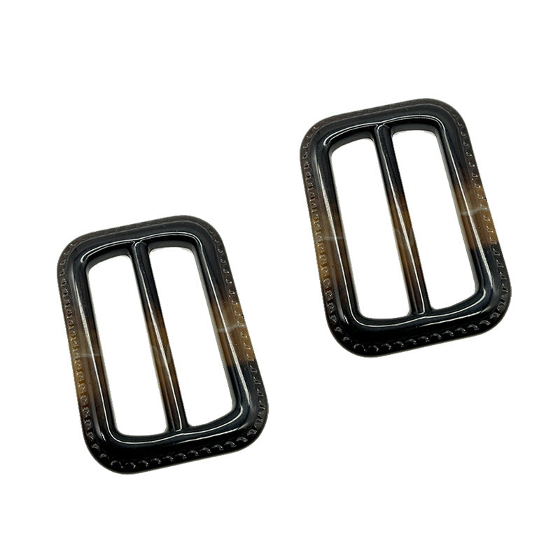 Two 40-mm resin D-ring buckles, black with brown accents