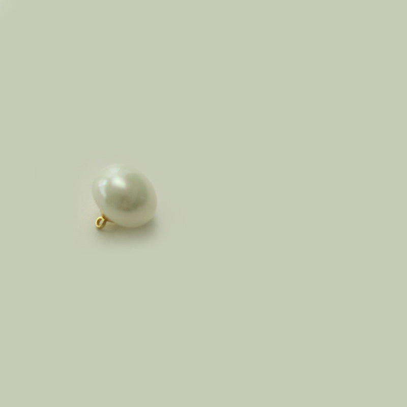 Round oblate white pearl button with small gold-tone metal shank loop