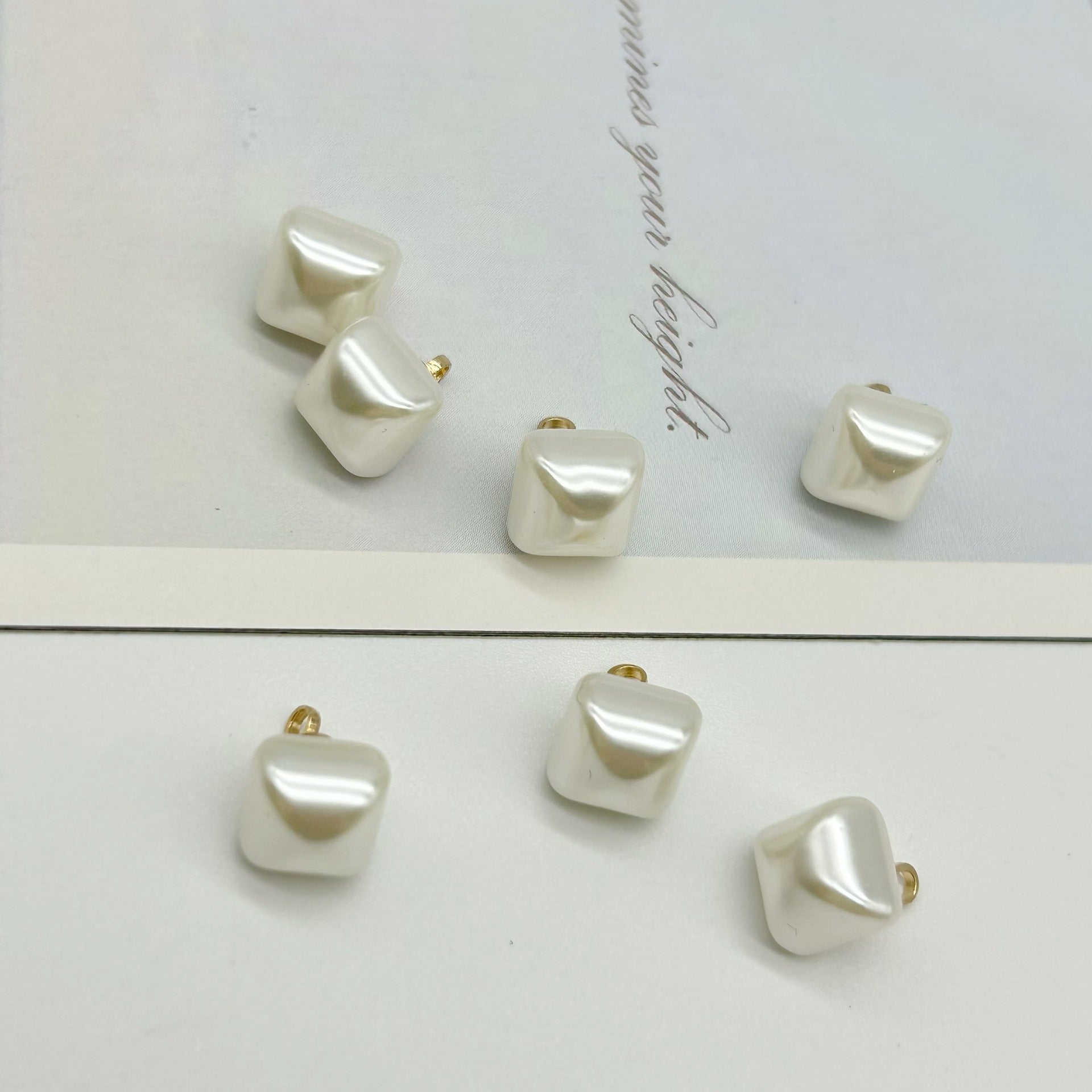 White square pearl buttons, glossy finish, metal loop backs
