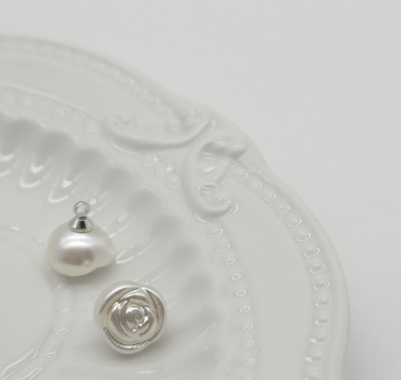 White pearl rose plastic buttons with metal shanks, showing front view