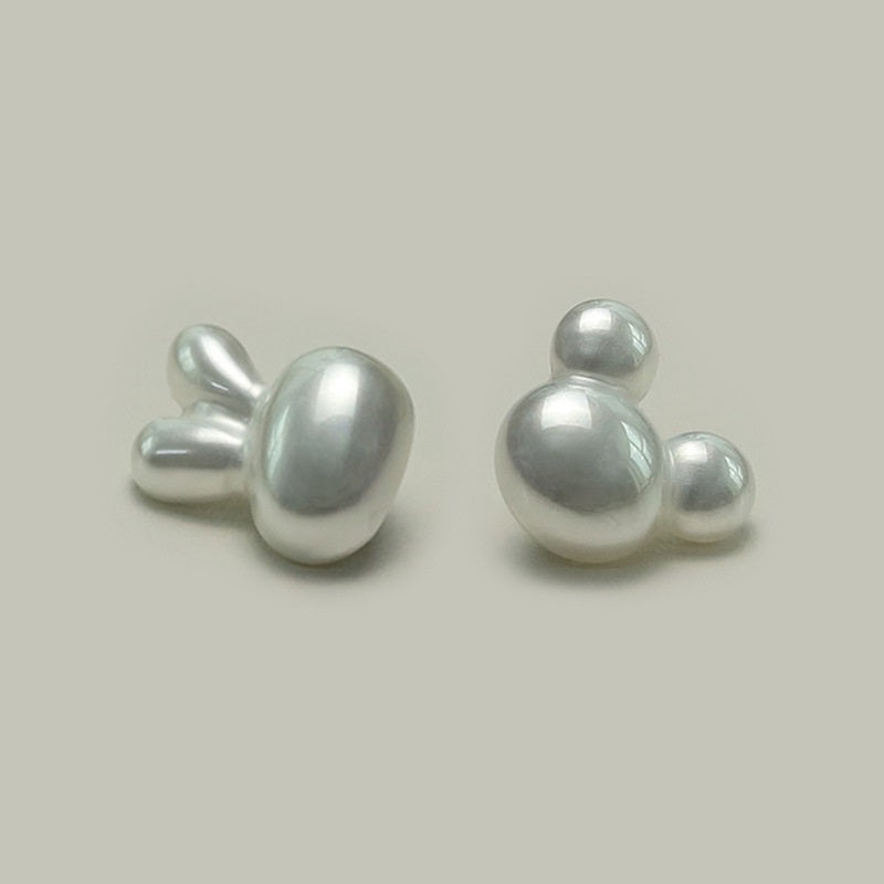 Pair of cartoon character plastic buttons with metal shanks, glossy light gray, top view
