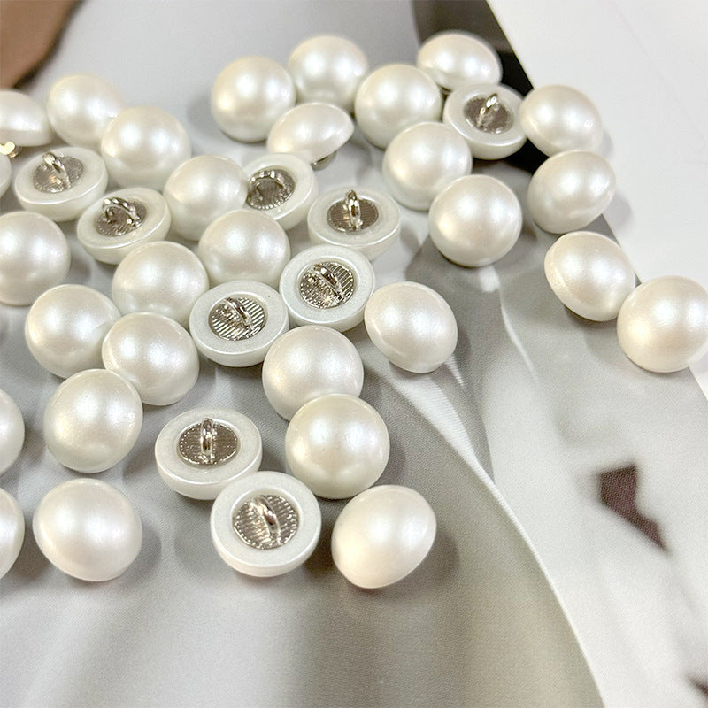 White pearl shirt cuff buttons showing silver metal shank backs