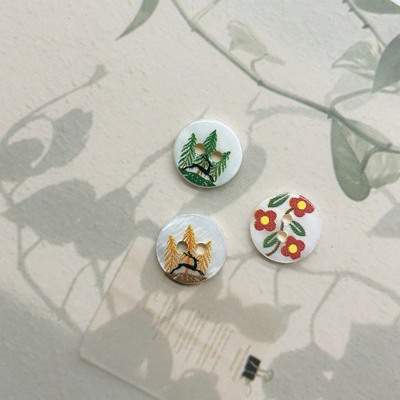 Set of two-hole shell buttons: deer in woods, pine tree, and red flower leaf design