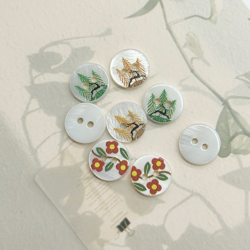 Six two-hole shell buttons: deer, pine branches, and red/yellow flower leaf motifs